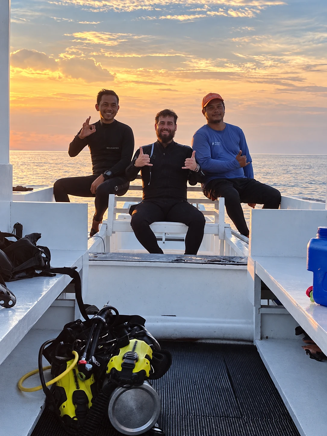 Ondra and two fellow divers on a boat at sunset